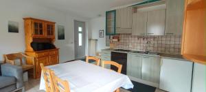 a kitchen with a table with a white table cloth at Il Terrazzino Val di Sole in Dimaro