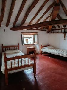a bedroom with two beds and a mirror in a attic at Casa de pelegrinos la perlanegra 