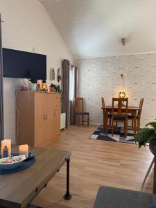 a living room with a television and a table at Strand 18b in Grebbestad