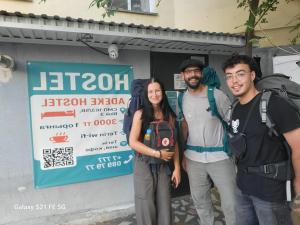 a group of three people standing in front of a sign at Adeke Hostel in Atyrau