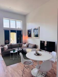 a living room with a couch and a table and chairs at Lomma Beach Town, New and Unique Apartment for Up to 4 Guests in Lomma