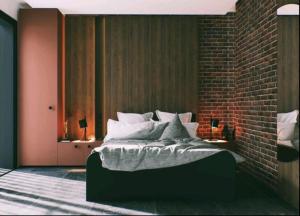 a bedroom with a bed with a brick wall at Villa Prestiž in Sokolac