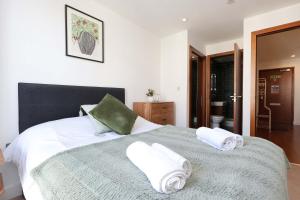 カーディフにあるCentral Apt-Parking-2Bed-2Bath-By FabAccommodationのタオルが敷かれた大きなベッドのある寝室