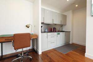 カーディフにあるCentral Apt-Parking-2Bed-2Bath-By FabAccommodationの白いキャビネットとデスク付きのキッチン