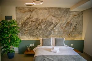 a bedroom with a large rock wall above a bed at Villa Prestiž in Sokolac