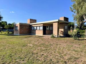 a brick house with a large yard in front of it at Dos Eucaliptus in Villa Rumipal