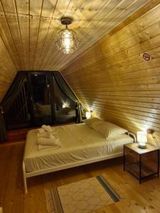 a bed in a room with a wooden ceiling at Cozy Cottage B in Kutaisi +15 photos