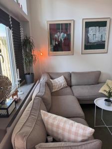 a living room with a couch and a table at Lomma Beach Town, New and Unique Apartment for Up to 4 Guests in Lomma
