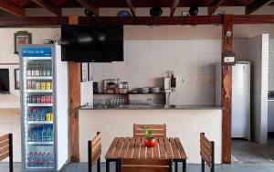 a kitchen with a wooden table and a refrigerator at Hostel Angatu Manaus in Manaus