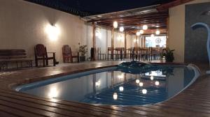 a swimming pool in a room with tables and chairs at Hostel Angatu Manaus in Manaus