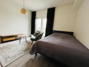 a bedroom with a bed and a chair and a table at Kiva yksiö kahdelle in Turku