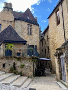 un vecchio edificio con un tavolo nel cortile di La Parenthèse a Sarlat-la-Canéda