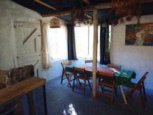 a dining room with a table and chairs and windows at Dormir con llamas in Maimará