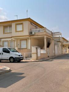 a white van parked in front of a house at Playa Flamenca 2 bed Apt Sol De Mar in Villamartin +18 photos