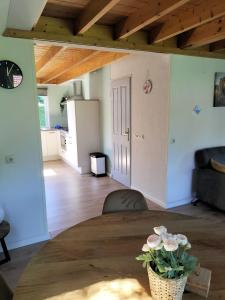 a living room with a table with a vase of flowers at Torenvalk I Genieten nabij Bos in Zwiggelte