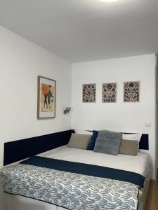 a bedroom with a bed and some pictures on the wall at Peppers Studio in Bucharest