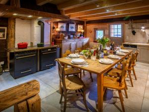 a large kitchen with a wooden table and chairs at Chalet Le Meridien Etale - OVO Network in Manigod