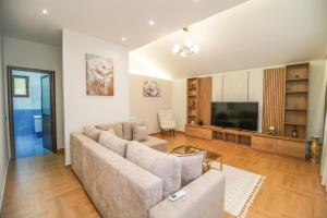 a living room with a couch and a flat screen tv at The Blue House in Shkodër