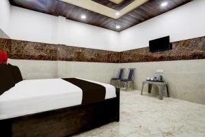 a bedroom with a bed and a flat screen tv at Hotel O R R GARDEN HOTEL in Kānpur