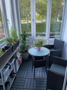 una mesa pequeña y sillas en una habitación con ventanas en Nahe Airport Ber Adlershof, en Schönefeld