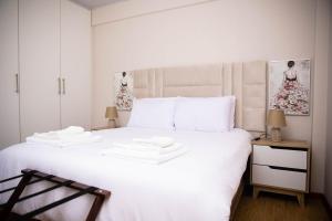 a bedroom with a large white bed with white sheets at At twelve Guesthouse in Gaborone