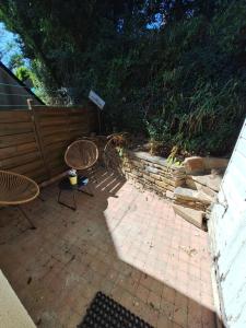 a patio with two chairs and a fence at maison POULDU in Clohars-Carnoët