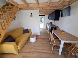 a living room and kitchen with a couch and a table at maison POULDU in Clohars-Carnoët