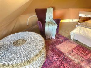 a room with a bed and a table and a rug at Karoo Stone Luxury River Tent in Ladismith