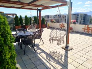 a patio with a table and chairs on a roof at Penthouse City View Infinity in Braşov