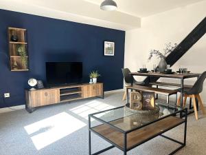Il comprend un salon doté d'une télévision et d'un mur bleu. dans l'établissement Blueberry View - Wyndale Living - Central Worcester, à Worcester