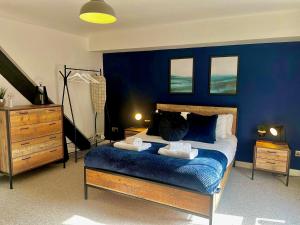 - une chambre dotée d'un mur bleu avec un lit et une commode dans l'établissement Blueberry View - Wyndale Living - Central Worcester, à Worcester 48 autres photos