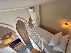 a room with a bed and a spiral staircase at Neoli in Jbeil