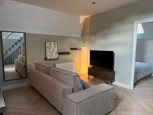 a living room with a couch and a flat screen tv at Naest - Authentic Escapes Old Town Villa Nijmegen in Nijmegen