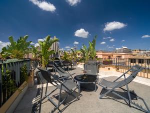 a row of chairs and a table on a balcony at LUXURY Terrazza Privata su Fontana di Trevi in Rome