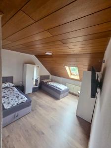 a room with two beds and a wooden ceiling at Wohnung Maric bis zu 10 Personen in Neunburg vorm Wald
