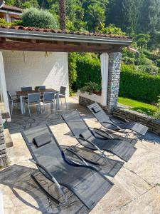 a patio with chairs and a table and a table and chairs at Carpe Diem in Brezzo