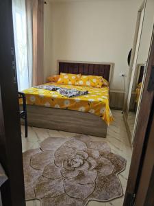 ein Schlafzimmer mit einem Bett mit gelber Decke in der Unterkunft Santorini Resort apartment in Dawwār Shindī Fannūsh