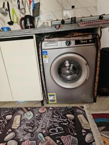 eine Waschmaschine unter einer Theke in einem Zimmer in der Unterkunft Santorini Resort apartment in Dawwār Shindī Fannūsh