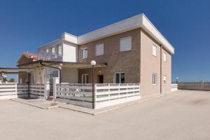 a large house with a white fence in front of it at Residence Horizont in Margherita di Savoia
