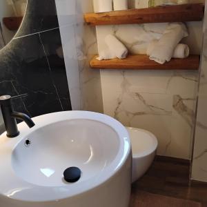 a bathroom with a white sink and a toilet at HOTEL ARIMANNIA Depandance in Caramanico Terme +13 photos
