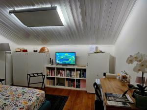 a room with a bed and a tv and a table at Mansarda Acquamarina in Viareggio +6 photos