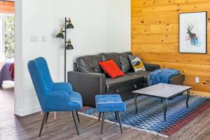 a living room with a couch and blue chairs at Spa Nature & Riverside Escape - Ecureuil Roux in Trois Rives