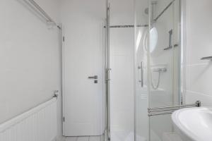 une salle de bain blanche avec une douche et un lavabo dans l'établissement Fewo Küstkieker, à Sankt Peter-Ording 19 autres photos