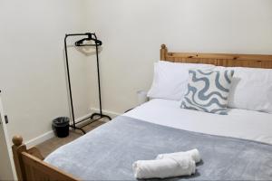 a bedroom with a bed with a towel on it at 4 bedroom home with games room - perfect for families, groups and contractors! in Thornhill