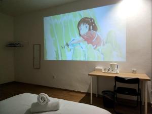 a large screen with a picture of a girl on a wall at Luna Suites Comfort Stay in Lahad Datu in Lahad Datu