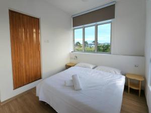 a bedroom with a white bed and a window at Luna Suites Comfort Stay in Lahad Datu in Lahad Datu