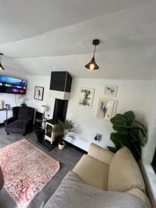a living room with a couch and a tv at Storeybook cottage in Oswestry