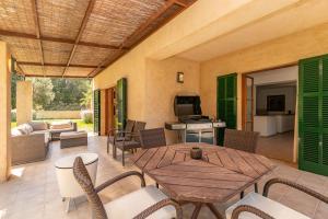a patio with a wooden table and chairs at Villa Comellar by Sealand Villas in Artá