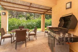 a patio with a grill and a table and chairs at Villa Comellar by Sealand Villas in Artá +26 photos