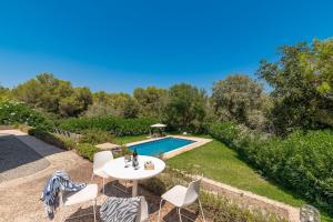 a patio with a table and chairs next to a pool at Villa Comellar by Sealand Villas in Artá